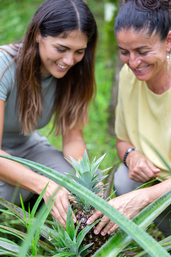 Reyna, owner of Galapagos Montemar Sustainable Villas and a guest observing a pineapple plantation grown on the island