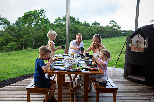 Family having breakfast outside, on the deck of Montemar Villa