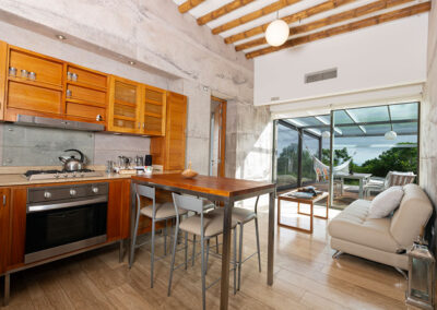 A view of the Luchuza Villa kitchen, sofa and outside deck