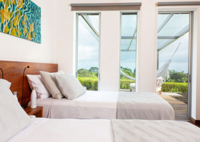 View from inside of the two bed bedroom in Tortuga Villa to the deck outside and vegetation