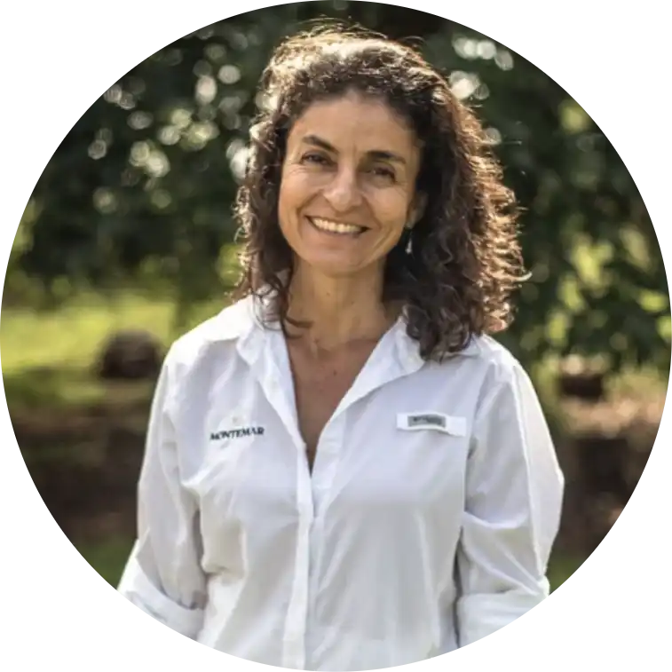 Smiling woman in white shirt standing outdoors.