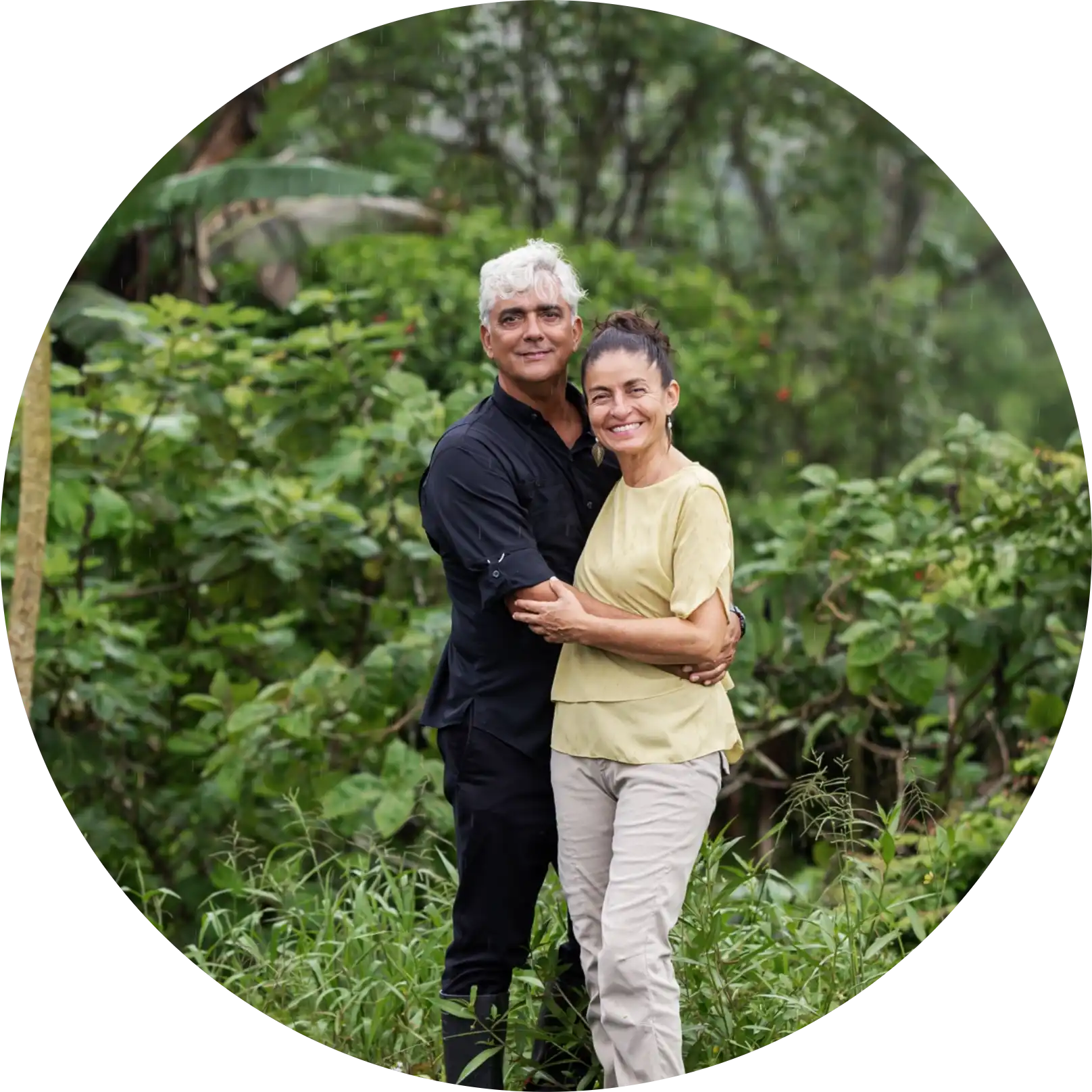 Couple standing and smiling in forest.