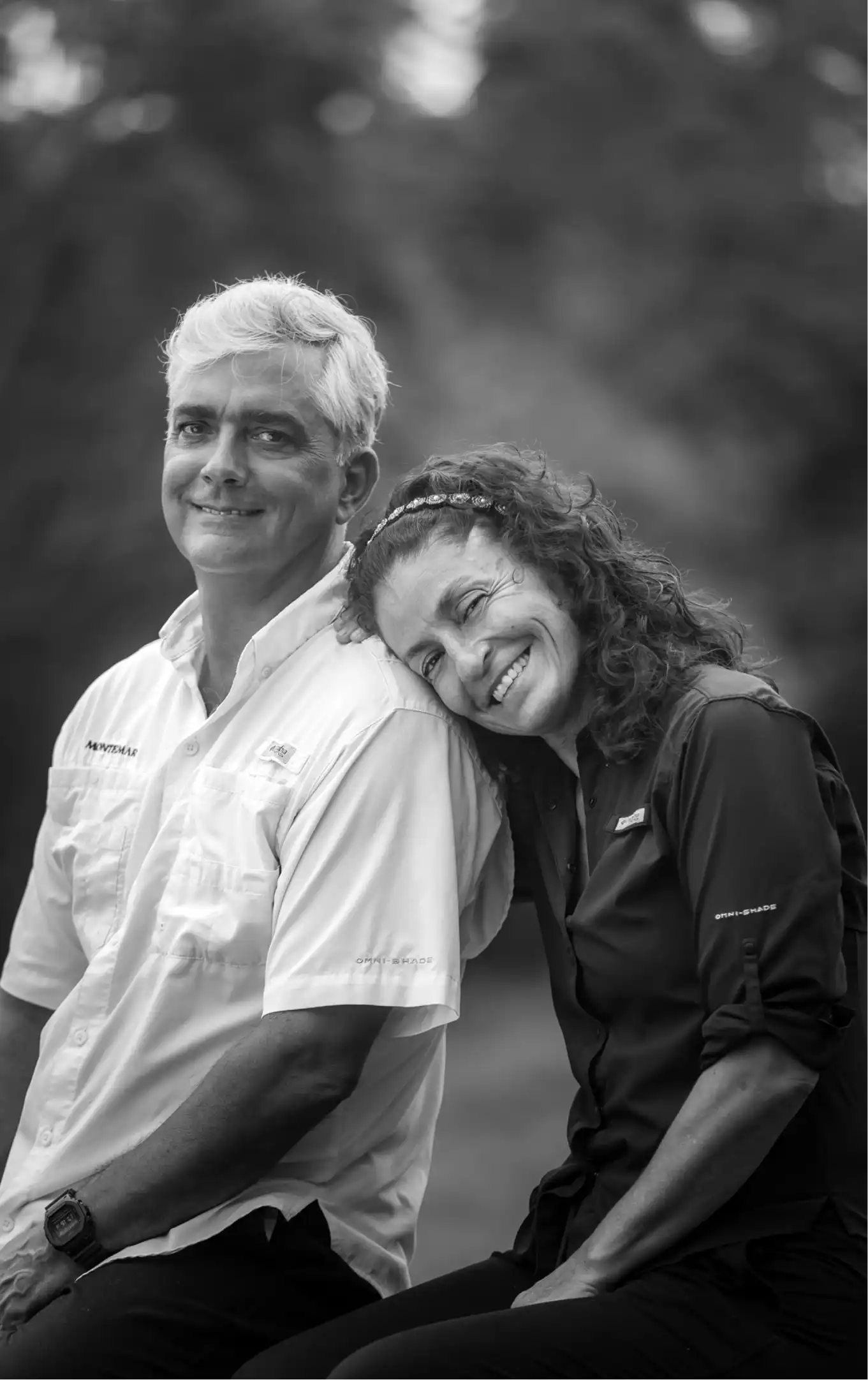 Smiling couple, woman leaning on man’s shoulder.