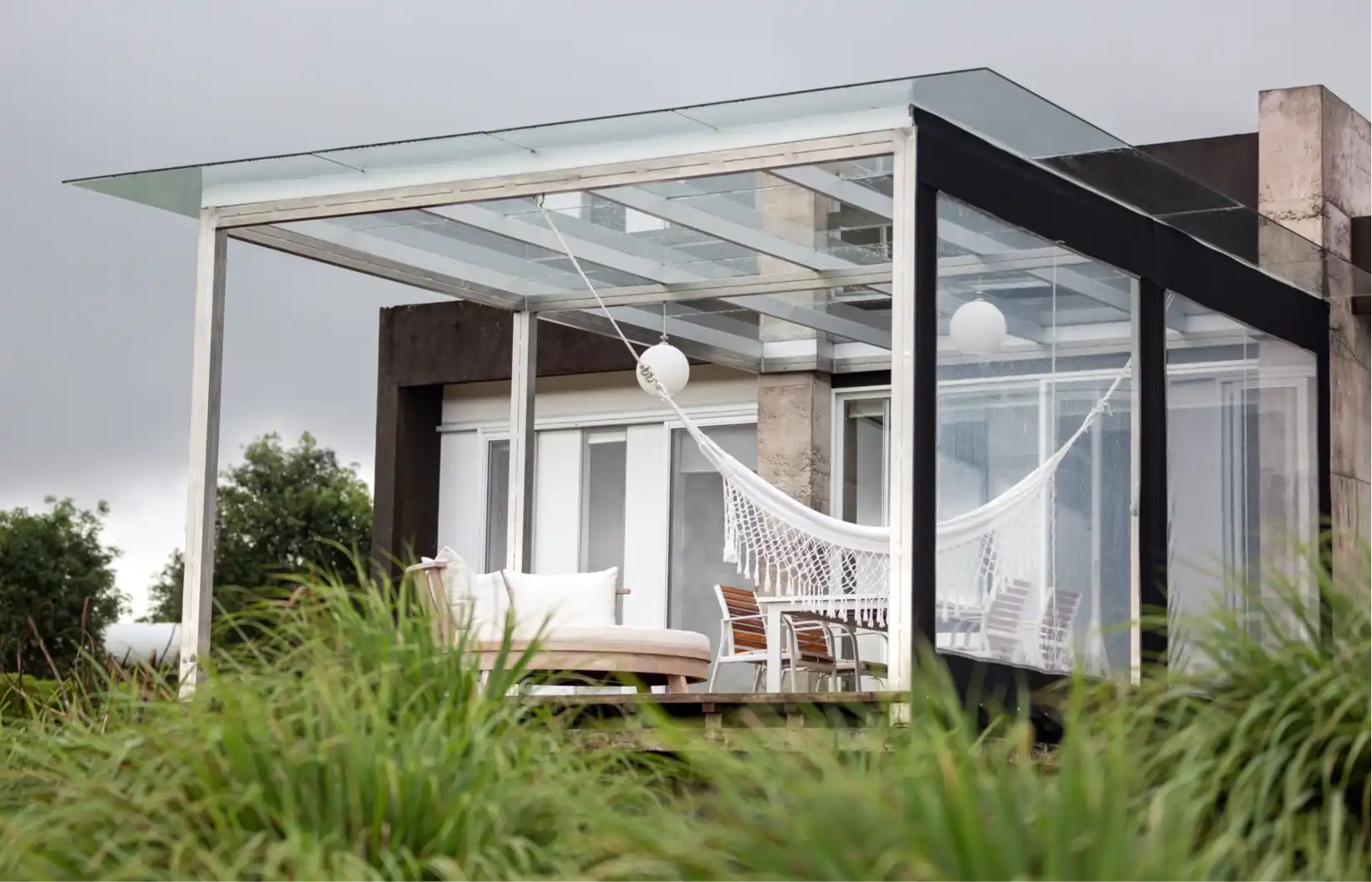 Casa con hamaca y estructura de vidrio